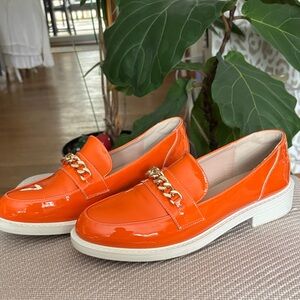 Vibrant Orange Patent Loafers with Gold Chain by [Brand]